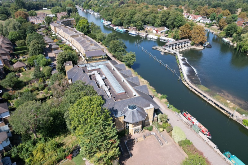 Aerial drone view of riverside property and surroundings