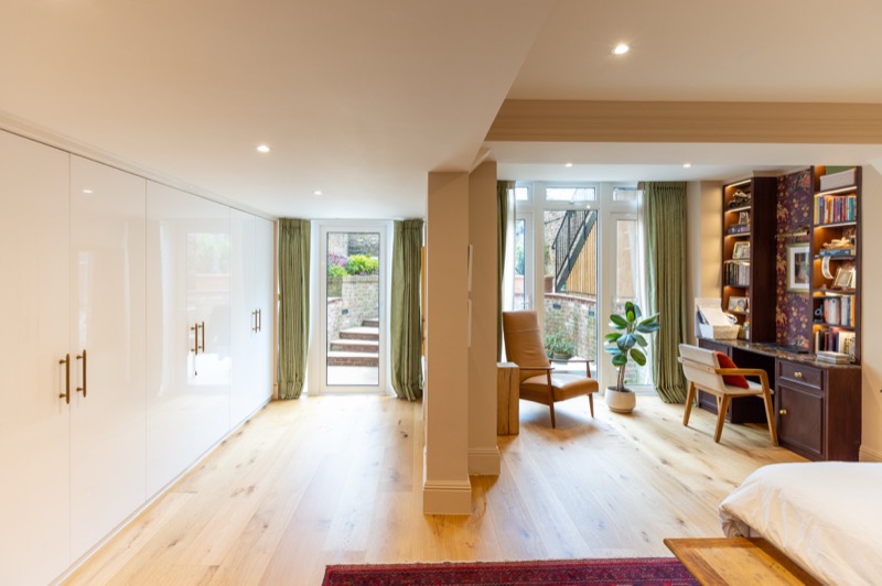 Open-plan bedroom suite with gloss fitted wardrobes, study corner and direct access to a walled garden terrace