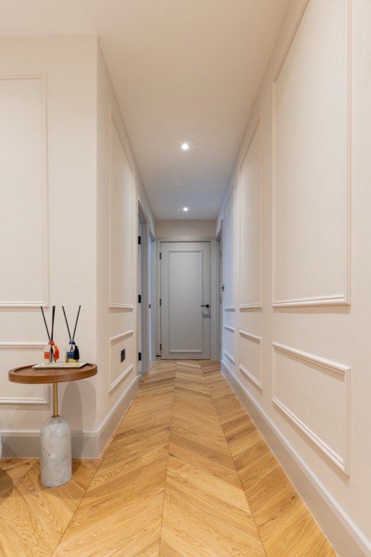 Luxury hallway leading to entrance with recessed lighting