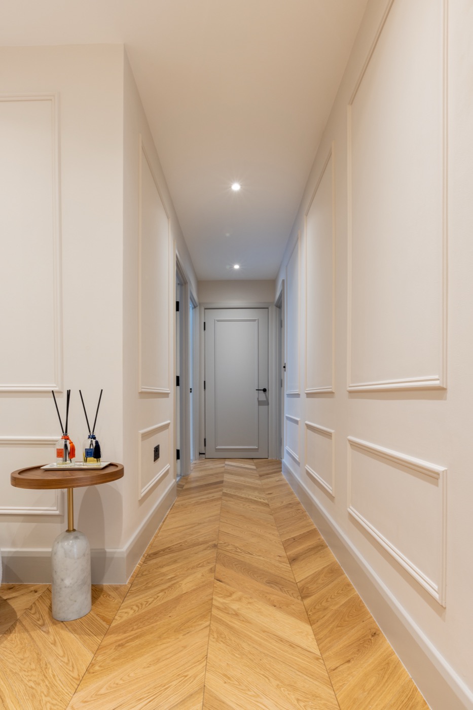Luxury hallway leading to entrance with recessed lighting