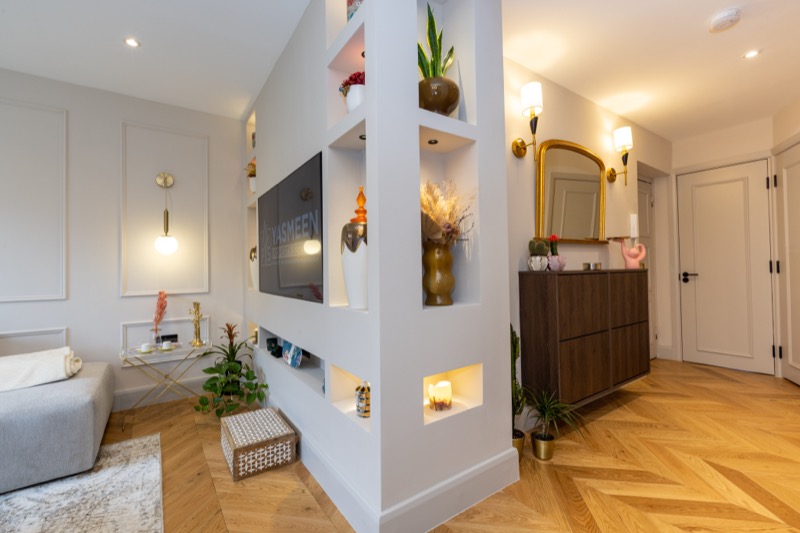 Open plan living with built-in shelving and herringbone flooring