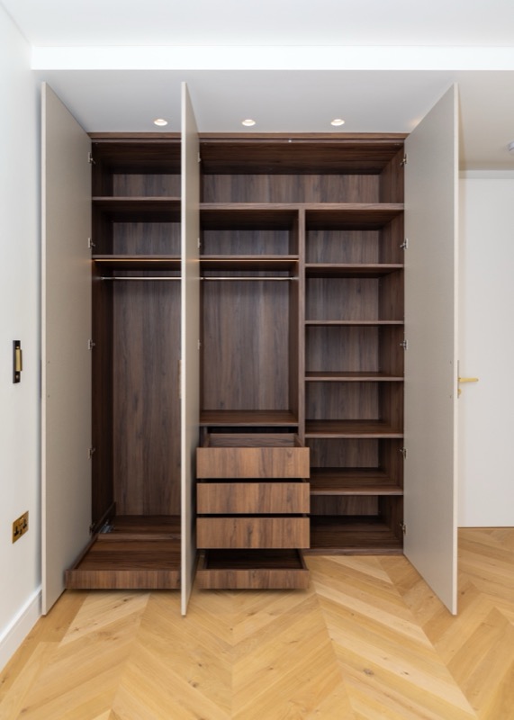 Bedroom with open wardrobe showing interior storage